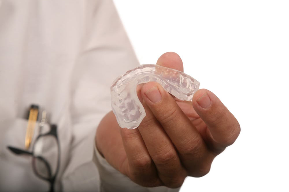 doctor holding mouth guard